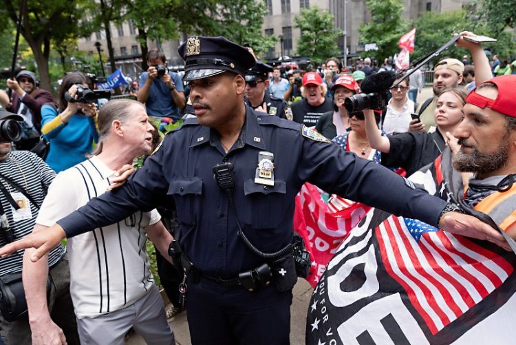 NYPD 경찰관이 2024년 5월 30일 법원 밖에서 트럼프 전  대통령의 지지자들과 트럼프 의 유죄 판결을 옹호하는 활동가를 제지하고 있다. 로이터