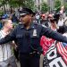 NYPD 경찰관이 2024년 5월 30일 법원 밖에서 트럼프 전  대통령의 지지자들과 트럼프 의 유죄 판결을 옹호하는 활동가를 제지하고 있다. 로이터
